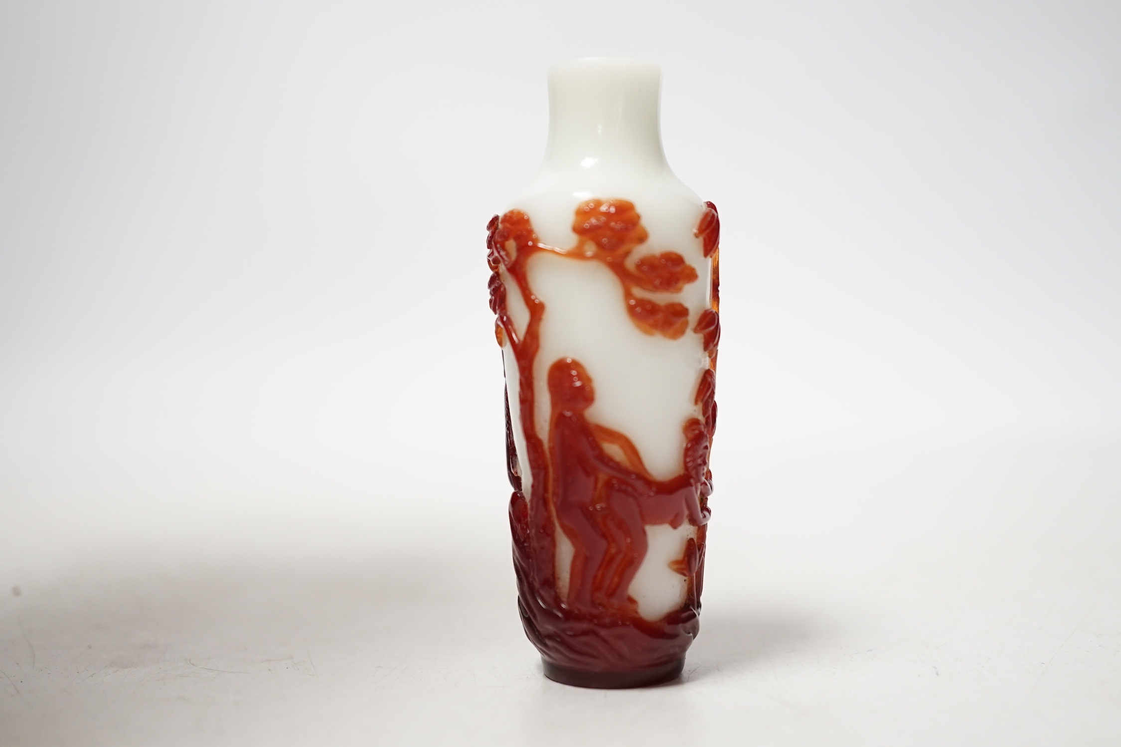 A Chinese ruby and white opaque glass erotic snuff bottle, early 20th century, 8cm high